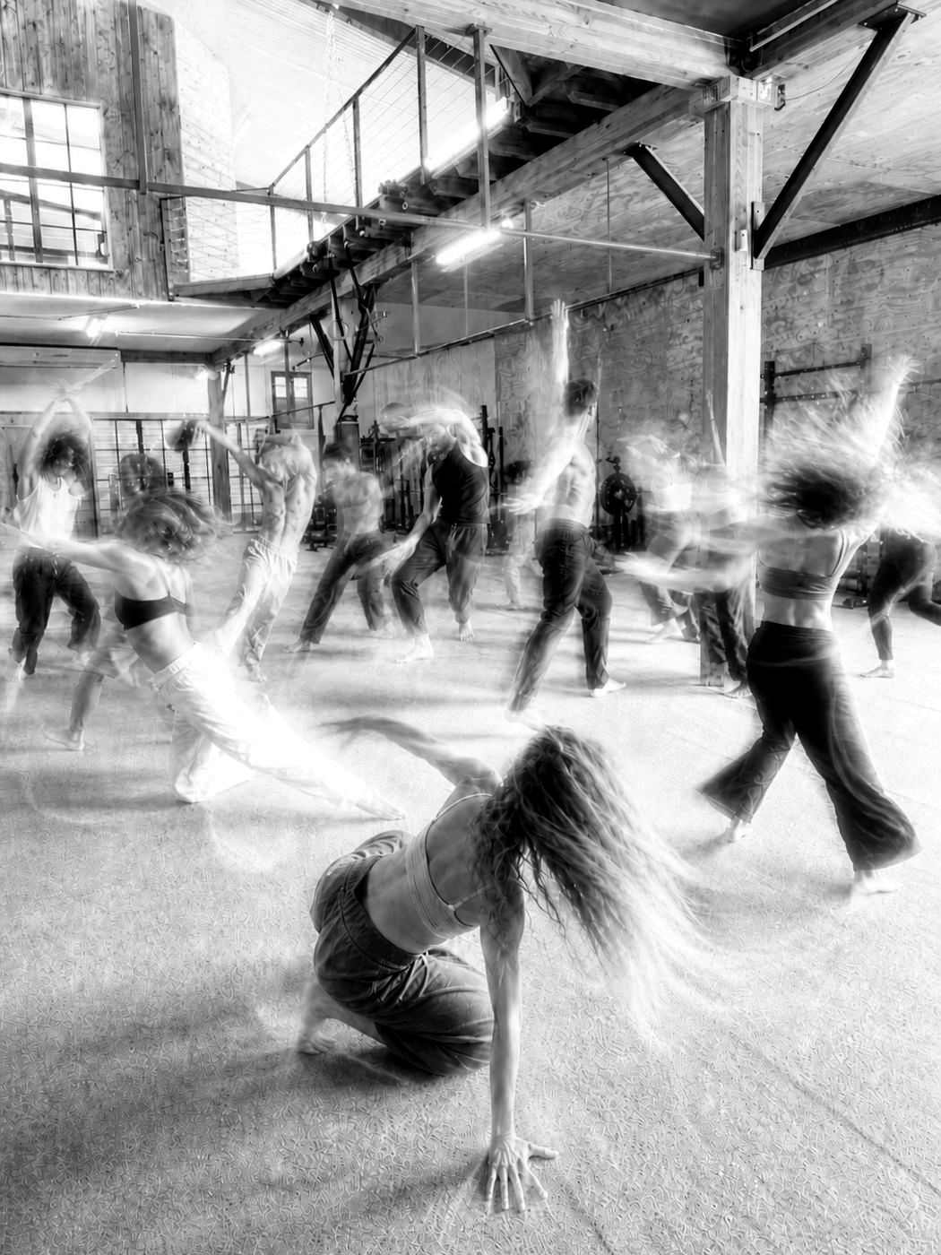 A group dancing freely in a sunlit wooden studio