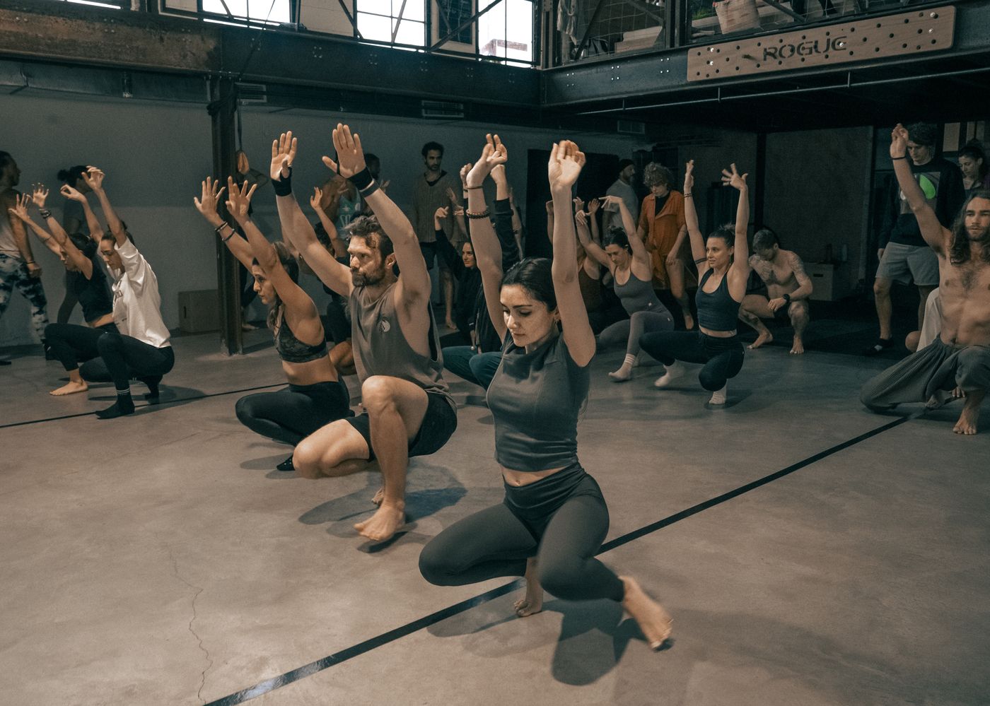 A group in a low squat with arms raised